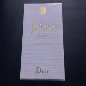 J'adore L'Or Essence de Parfum från Dior - Exklusiv parfym från Dior, J'adore L'Or Essence de Parfum, i en elegant förpackning. Denna doft är känd för sin lyxiga och sensuella karaktär, perfekt för speciella tillfällen. Flaskan rymmer 40 ml av denna förföriska essens.