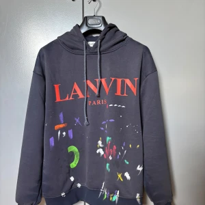 Lanvin x Gallery dept Hoodie - Tjena! Säljer en mörkblå hoodie från Lanvin med röd text och färgglada detaljer. Köpt på Lanvin i Paris tidigare i år så självfallet äkta. (Endast tag medföljer) Storlek M med en lite större passform. Kom med relevanta bud (köpt för 6500) och byten kan vara intressant. Hör av dig vid minsta fråga😊//Algot