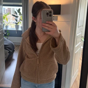 Beige teddyjacka med dragkedja - Mysig beige teddyjacka från H&M med dragkedja (helt slutsåld). Jackan har en avslappnad passform och långa ärmar, perfekt för kyliga dagar så som våren och sommarkvällar. Den är tillverkad i ett mjukt och fluffigt material som ger en skön känsla. 