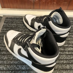 Nike Dunk Mid svart/vit sneakers - Säljer ett par nike dunk mid sneakers i svart/vit. Använd varsamt, bra skick!