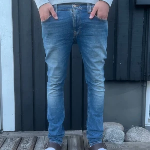 Nudie jeans - Tja, ett par riktigt snygga nudie jeans med en bra passform samt snygg färg. Nypris runt 1500kr, storlek 31/32, skick: 8/10 en liiiten defekt som ni ser på sista bilden, men syns absolut inte vid användning. Bara att be om fler bilder så löser jag då jag tog dessa bilder lite snabbt. Hör av er för mer information! Mvh Elton