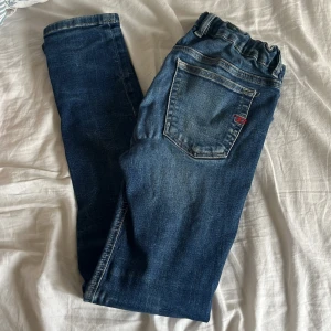 Blå jeans från Diesel slim/skinny fit - Hej säljer mina ett år gamla diesel jeans med lite slitna detaljer på! Jeansen är storlek 12 år 156cm och passar nån mellan  150-160 men kan passa större men då sitter de mer som skinny fit. Passformen är slim fit/skinny fit och sitter normalt i storlek. Nypris kosta runt 800kr men säljer för 399kr jeansen är i bra skick skriv om ni undrar nåt mvh Arvid 