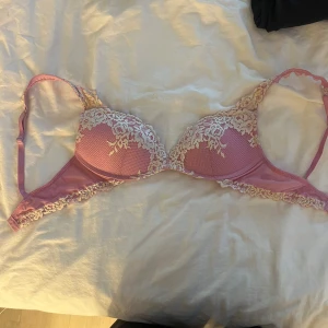 Rosa spets bandeau tubtopp - Säljer en söt rosa bandeau tubtopp med ljus spetsdetalj framtill. 75B