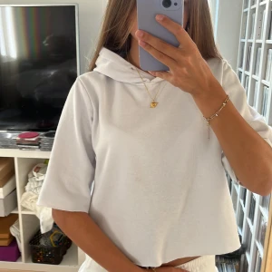 Vit hoodie med korta ärmar - Säljer en vit hoodie med korta ärmar och huva. Tröjan har en avslappnad passform och är gjord i mjukt bomullsmaterial💕