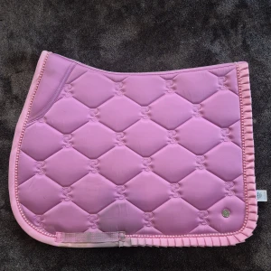 Rosa PS schabrak stl FULL - Säljer mitt hoppschabrak i storlek full i märket PS. Schabraket är endast använt 2 gånger så väldigt bra skick! Är endast lite smuts där saddlgjorden suttit! 