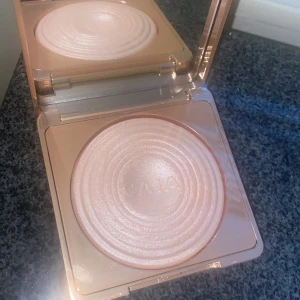 Cava highlighter i champagne-ton - Superfin highlighter från Cava i en lyxig guldig förpackning. Pudret har en skimrande champagnefärg och en snygg vågig yta. Perfekt för att ge glow till kindben, näsa och amorbåge. Kommer i en spegelförsedd dosa.