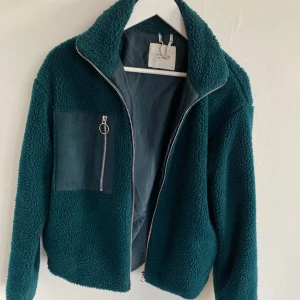 Mörkgrön teddyjacka - Teddyjacka i mörkgrönt. Perfekt för dig som vill ha en mysig och trendig look under kyliga dagar.