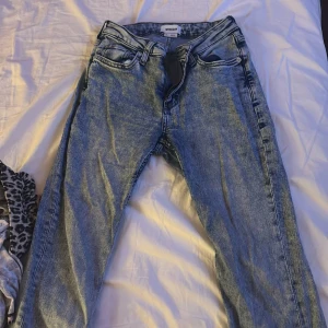 Blå Weekday jeans  - Säljer ett par klassiska blå jeans från Weekday flare. Jeansen har fem fickor, bälteshällor och dragkedjegylf. De är tillverkade i bomull och har en snygg tvättad look med ljusare partier. Perfekta för en chill och stilren vardagsstil.
