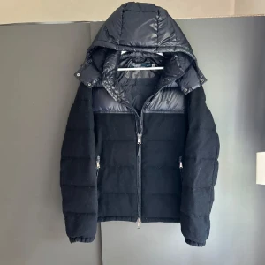 Mörkblå dunjacka från Polo Ralph Lauren - Snygg mörkblå dunjacka från Polo Ralph Lauren med dragkedja och avtagbar huva. Jackan har en quiltad design och är perfekt för kyliga dagar. Den har praktiska fickor med dragkedja för säker förvaring. Nypris ligger på 6500kr, mitt 4500kr men går att diskuteras. Skick 9/10 utan några detekter eller liknande. 