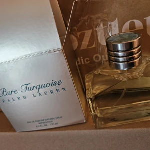 Pure Turquoise parfym Ralph Lauren - Exklusiv parfym från Ralph Lauren, Pure Turquoise, i en stilren glasflaska med geometrisk design. Locket är silverfärgat med en snygg turkos marmorerad detalj på toppen. Flaskan rymmer 125 ml och doften är Eau de Parfum.