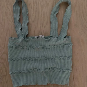 Ljusgrön ribbad linnetopp från Zara - Superfin ljusgrön ribbad linnetopp från Zara med volangdetaljer och breda axelband. Toppen är croppad och har en mjuk, stretchig känsla. Kan mötas på Ekerö annars står köparen för frakten. Använd 1 gång 