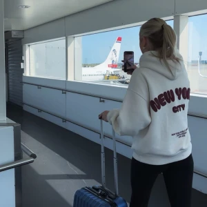 Vit hoodie med New York City-tryck - Säljer en vit hoodie med stor huva och coolt New York City-tryck i rött på ryggen. Tröjan har en relaxed passform och är perfekt för att chilla eller resa i. Mjuk bomullskänsla och klassisk look som funkar till svarta jeans eller tights.