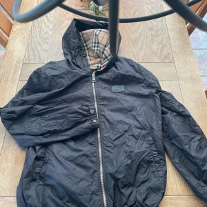 Burberry reversible chelljacket - Säljer nu denna överfeta reversible burberry jackan. Jackan har dässvärre ett brännhåll på ”Burberry” sidan av jackan vilket inte syns alls när man har på sig den då den är revirsible, och därav det låga priset. Kom pm för mer information eller bilder. Det är ok att köpa direkt, fraktas samma dag eller dagen efter beroende på tid.