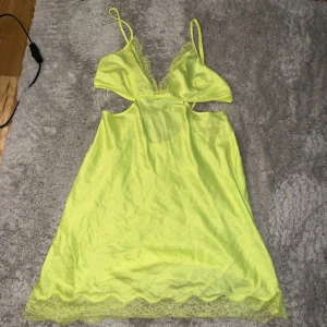 Nattlinne  från Victoria's Secret - Supersnygg gul kortklänning från Victoria's Secret i satin med spetsdetaljer vid bysten och nederkanten. Klänningen har smala axelband, omlottöppning i ryggen och en v-ringad front. Perfekt för dig som gillar färgstarka och trendiga plagg!  PASSAR M med