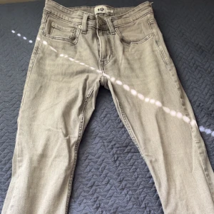 Grå jeans från 157, slim fit - Snygga grå jeans från 157 med klassisk femficksdesign och raka ben. Jeansen har normalhög midja och är tillverkade i mjukt bomullstyg med en lätt tvättad look. Perfekta för dig som gillar en enkel och clean stil.