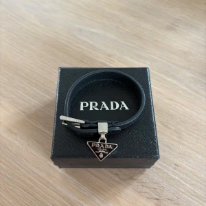 Prada armband - Säljer mitt helt oanvända Prada armband som är i topp skick, skick 10/10. Är öppen för frågor och prisförslag:)