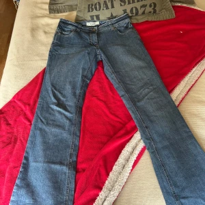 Blå bootcut jeans från Clara, stl 42 - Snygga blå jeans från Clara i bootcut-modell med broderade detaljer på bakfickorna. Klassisk femficksdesign och normal passform. Jeansen är tillverkade i denim och har en cool, tidlös look som passar till det mesta. Säljer dessa för jag inte kan ha dom dom sitter för stort runt min midja fast dom är bra i längden för en tjej som är 163.