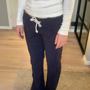 Mörkblå mjukisbyxor med snörning - Säljer ett par mörkblå linnebyxor med vit snörning i midjan. Märke Roxy 