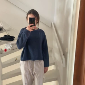 Blå stickad tröja - Säljer en mysig blå stickad tröja med rund hals och långa ärmar. Perfekt för kyligare dagar och enkel att matcha med olika outfits. Tröjan har en avslappnad passform och är superbekväm att bära.