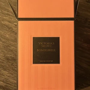 Bombshell Eau de Parfum från Victoria's Secret - HELT NY! Endast Sprutad 3 ggr men pågrund av allergisk reaktion så säljer en 100 ml flaska av Bombshell Eau de Parfum från Victoria's Secret. Flaskan har en sofistikerad design med en klar kristalliknande kork och en rosa tonad glasflaska. Förpackningen är stilrent rosa med svarta detaljer.