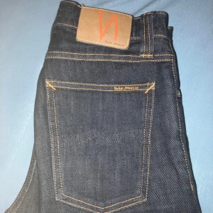 Mörkblå jeans från Nudie Jeans - Riktigt feta mörkblå jeans från nudie, modellen är high kai! Dessa sitter slim på mig men är mer åt skinnyhållet enligt Google. Storlek: W27 L32. Inga defekter💯 pris kan sänkas vid snabb affär🔥