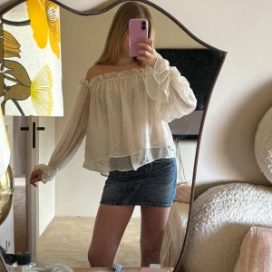 Vit offshoulder blus - Säljer en söt vit offshoulder blus med prickigt mönster. Blusen har långa ärmar och en luftig passform, perfekt för en somrig look. Den är gjord i ett lätt och bekvämt material. Den är från Gina Tricot. 