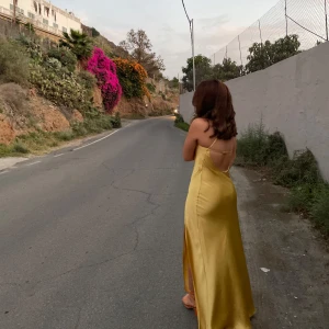 Gul klänning från zara - Elegant gul långklänning med en slits och asymmetrisk design. Perfekt för bal eller liknande. Använd få gånger