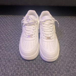  Air Force 1 - Säljer ett par klassiska vita Nike Air Force one sneakers.  Perfekta för en casual look. SKORNA ÄR SPRILLANS NYA! Äkta och kvitto finns, köpte för stor storlek, storlek 42,5/43.