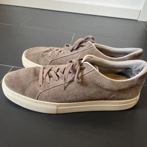 Bruna mockasneakers från Vagabond - Snygga bruna sneakers i mocka från Vagabond. De har en klassisk design med snörning och en bekväm vit sula. Perfekta för en stilren vardagslook. Mycket bra skick utanpå inga fläckar osv och fortfarande vit sula, bara inuti lite slitna inget som syns. 