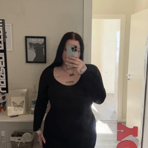 Svart långärmad klänning från Motel - Säljer en stilren svart långärmad klänning från Motel. Klänningen har en v-ringad design och är perfekt för en elegant look. Den är tillverkad i ett mjukt och bekvämt material som ger en smickrande passform. Perfekt för att klä upp eller ner beroende på tillfälle.