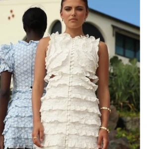 Vit klänning med volanger - Snygg vit klänning med volanger och cut-out detaljer. Perfekt som studentklänning! Klänningen har en kort längd och är ärmlös. Endast använd 1 gång