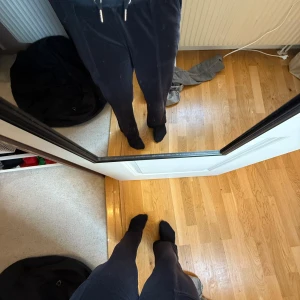 Svarta byxor från Juicy Couture - Säljer ett par svarta byxor från Juicy Couture. Byxorna har en loose passform med hög midja och är tillverkade i ett mjukt material. De har snörning i midjan och fickor både fram och bak med knappar.