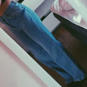 Blå jeansbyxor - Snygga blå jeansbyxor med hög midja och rak passform. Perfekta för en avslappnad stil. Klassisk design med fem fickor och knappgylf. Waist: 25 Length: 32