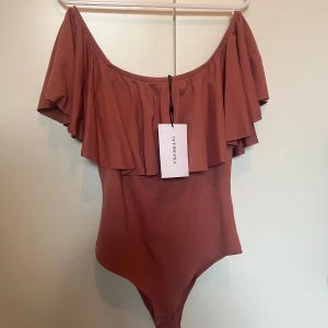 Rosa/röd body - Rosa/röd body med volang från IVYREVEL. Helt oanvänd och jättesnygg💗säljer då jag inte är så mycket för bodys💗pris går att diskutera 