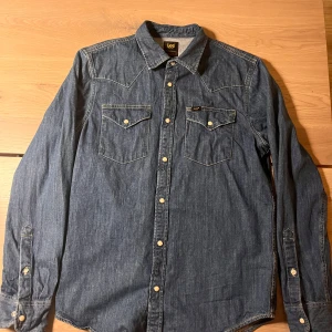 *ny*Jeansskjorta från Lee - Snygg jeansskjorta från Lee med klassisk design och tryckknappar. Skjortan har två bröstficko. Använd en gång  storlek M