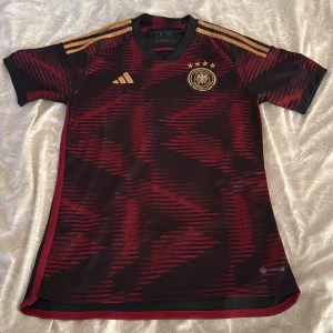 2022-2023 Tyskland bortatröja  - Jag säljer min tröja på grund av att jag snabbt hunnit växa ur den, skicket och kvalitén på tröjan är precis som nytt, inga andra bemärkelser på tröjan.