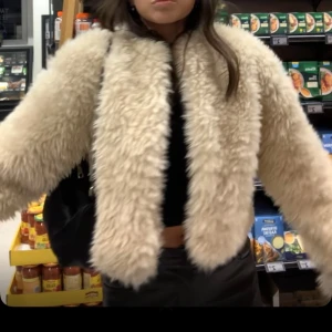 Beige pälsjacka från Gina Tricot - Säljer en fluffig och trendig beige pälsjacka från Gina Tricot.