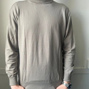 Ermenegildo zegna polotröja - Säljer en stilren beige polotröja från ermenegildo zegna med ribbade detaljer vid krage, ärmslut och nederkant. Perfekt för en minimalistisk look. Tröjan har långa ärmar och är tillverkad i ett mjukt material. Defekter som visas på bilderna. Storlek M. Nypris ligger runt 12000kr 