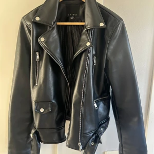 Svart skinnjacka från Amisu - Snygg svart skinnjacka från Amisu/New yourker med dragkedja och knappar. Använd fåtal gånger! Perfekt jacka inför våren/sommarkvällar💜🩷