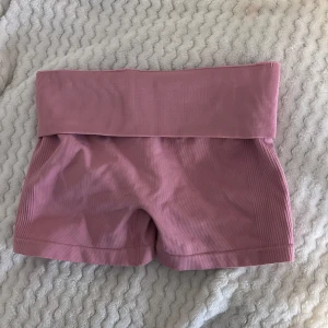 Rosa tränings shorts  - Säljer ett par snygga rosa tränings shorts. Dom har scrunch i bak. Dom är testade men aldrig använda, då dom inte passade! Går att ha hög midjat men även att vika ner så man kan få dom lägre i midjan. Skriv jätte gärna vid frågor 🥰😌