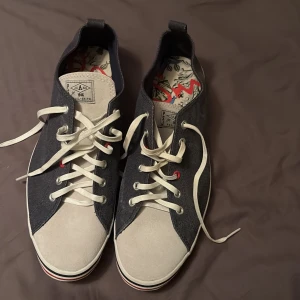 Paul Smith sneakers i blått och vitt - Snygga sneakers från Paul Smith i en stilren kombination av blått och vitt. Skorna har vita snören och en klassisk rund tå. Tillverkade i Vietnam med en cool design på insidan. Perfekta för en avslappnad stil.