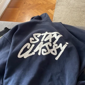Mörkblå hoodie med Stay Classy-tryck - Säljer den hära mörkblåa hoodie från Subdued, ”Stay Classy” med stort vitt tryck på ryggen. 🥰🥰 Super fin, i storlek xs pris kan diskuteras 🫶🏻🫶🏻🫶🏻