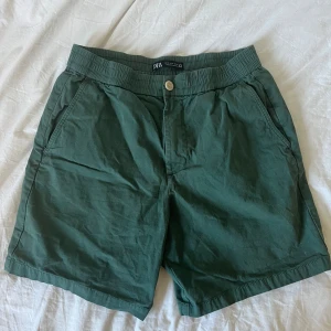 Gröna shorts från Zara  - Snygga gröna shorts från Zara med elastisk midja och knapp framtill. Använd ett par gånger men ändå i bra skick - Storlek S