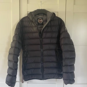 Colmar jacka storlek M/50 - Tja! Säljer nu min svarta vinterjacka från Colmar med huva och snygga horisontella kanaler. Den är i storlek 50 som är Medium! Jackan har dragkedja framtill och två sidofickor med dragkedja. loggan är på vänster ärm. Den är perfekt för dig som vill ha en stilren och varm jacka med modern look perfekt till hösten och vintern!