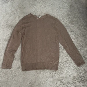 Beige prickig stickad tröja från Mywearwoman - Säljer en beige stickad tröja från Wera med diskreta prickar i materialet. Tröjan har rund hals och långa ärmar, perfekt för dig som gillar enkel men snygg stil. Mjuk och skön kvalitet som passar till jeans eller kjol.