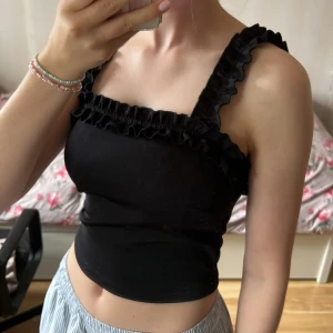 Svart linnetopp med volang - Volangtopp från Ginatricot!