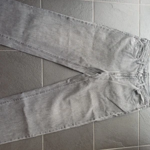 Grå Levi's 568 jeans W33 L34 - Säljer ett par grå Levi's 568 jeans med klassisk femficksdesign och snyggt läderpatch bak. Jeansen har rak passform och är tillverkade i slitstarkt denim. Perfekt för dig som gillar en clean och tidlös look.