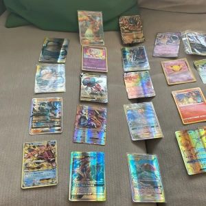 Pokémon GX & VMAX Collection - Samling med coola Pokémon GX och VMAX-kort, inklusive favoriter som Charizard, Mew, Blaziken och Celebi. Perfekt för dig som älskar att samla, spela och byta Pokémonkort! Flera holografiska och sällsynta kort som gör din samling extra unik.