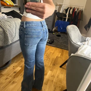 Blå bootcut jeans med låg midja, storlek 158 barn - Säljer ett par snygga blå jeans med bootcut passform och låg midja. Jeansen har klassiska fickor både fram och bak, och är gjorda i mjukt denimtyg som sitter skönt. Perfekta för dig som gillar en retro vibe och vill ha lite utsvängda ben.  Helt oanvända 