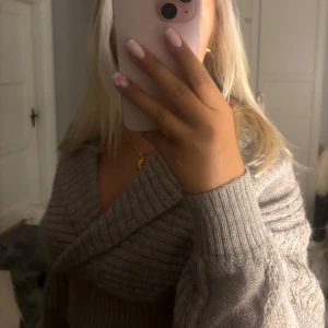 Grå croppad omlott kofta - Säljer en super härlig croppad kofta med snygg urringning. Sitter som en S, jätte fin till hösten 🤗